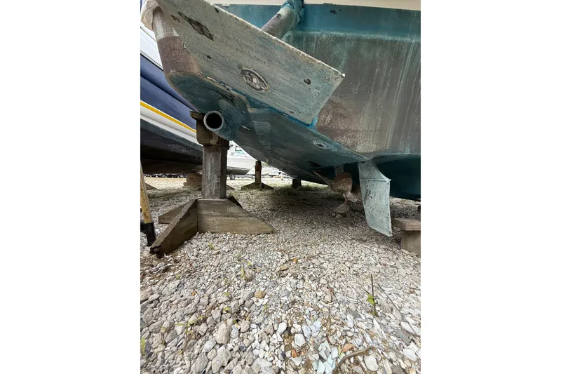 Slide: The Image of Underneath view of a 2000 Sea Ray 310 Sundancer boat on gravel. - 38