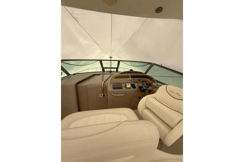 Slide: The Image of Interior view of 2000 Sea Ray 310 Sundancer boat cockpit with beige seating. - 9