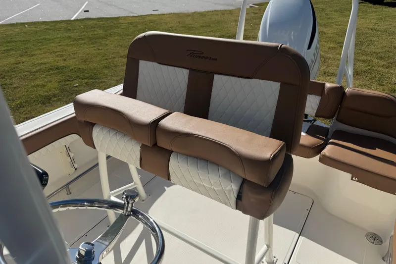 Slide: The Image of 2026 Pioneer 222 Islander boat interior with brown and white cushioned seating. - 11