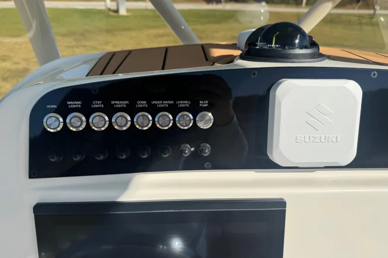 Slide: The Image of Control panel of 2026 Pioneer 222 Islander boat with Suzuki branding and various light switches. - 14