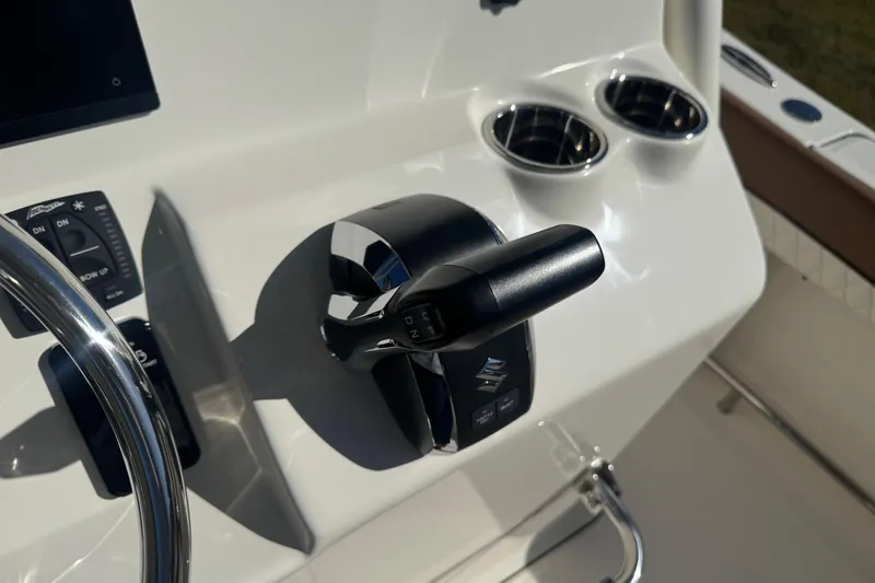 Slide: The Image of 2026 Pioneer 222 Islander boat control panel with throttle and cup holders. - 18