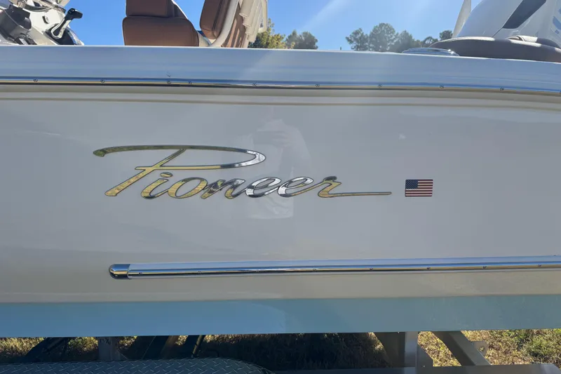 Slide: The Image of 2026 Pioneer 222 Islander boat with American flag emblem. - 2