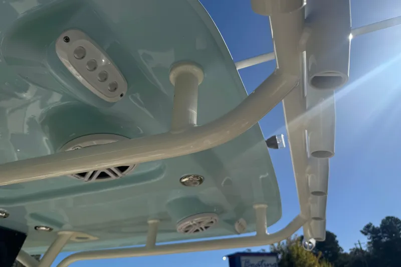 Slide: The Image of 2026 Pioneer 222 Islander boat roof with speakers and rod holders under clear sky. - 22