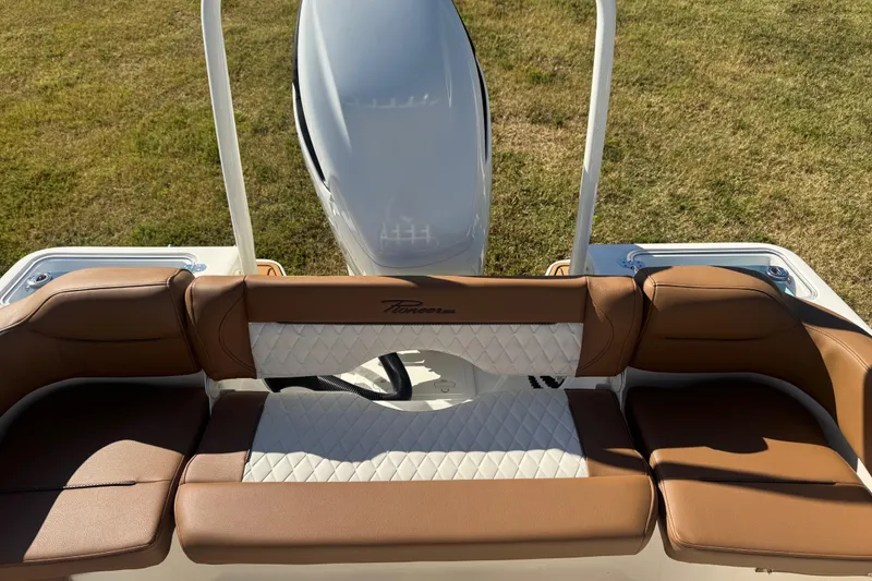 Slide: The Image of 2026 Pioneer 222 Islander boat seating with brown and white upholstery, outdoor setting. - 23