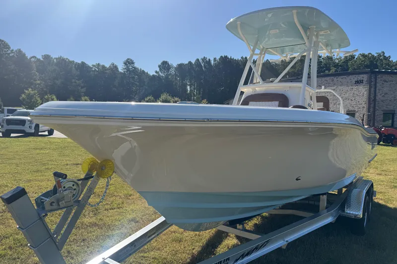 Slide: The Image of 2026 Pioneer 222 Islander boat on trailer, parked on grass under clear sky. - 4
