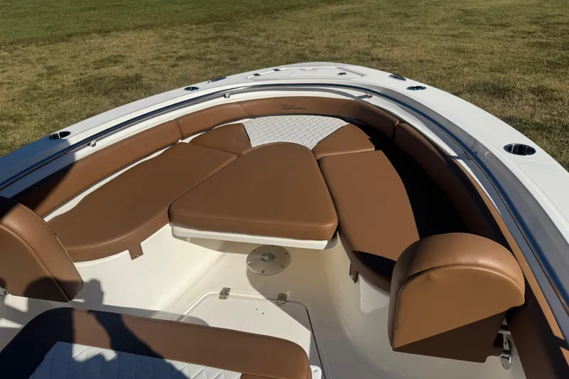 Slide: The Image of 2026 Pioneer 222 Islander boat interior with brown cushioned seating and white accents. - 7