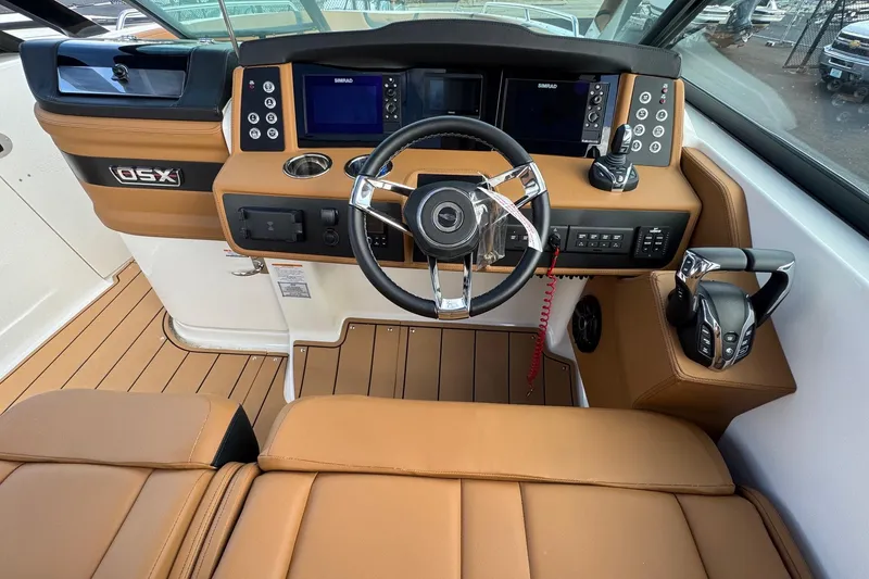 Slide: The Image of 2024 Chaparral 280 OSX boat cockpit with modern controls and tan leather seating. - 10