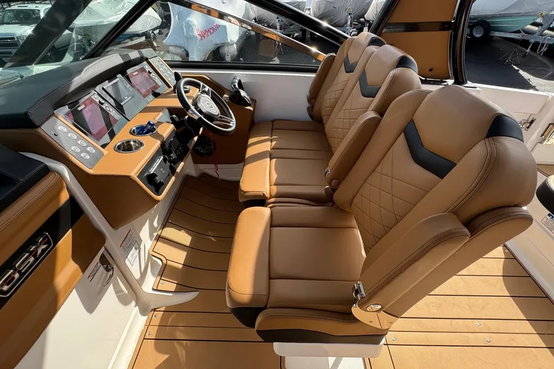 Slide: The Image of 2024 Chaparral 280 OSX boat interior with luxurious tan leather seating and modern dashboard. - 12