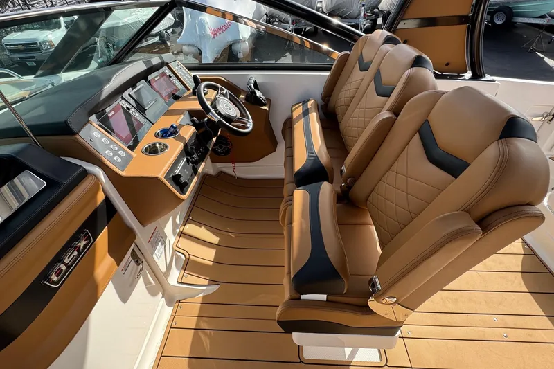 Slide: The Image of 2024 Chaparral 280 OSX boat interior with luxurious tan seating and modern dashboard. - 13