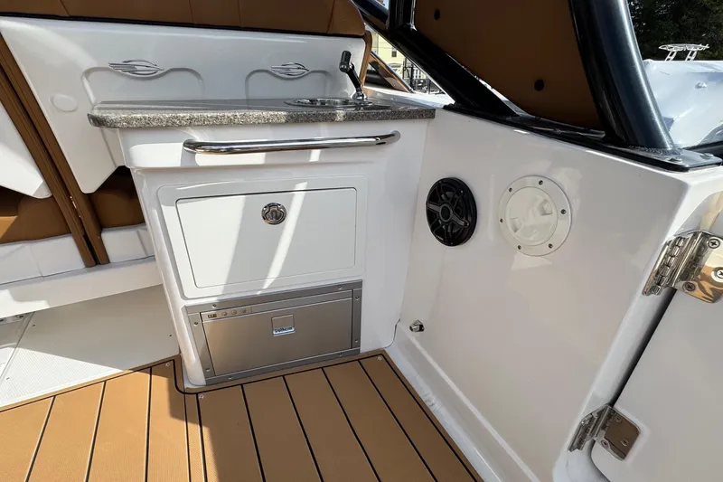 Slide: The Image of 2024 Chaparral 280 OSX boat interior with sink, storage, and speaker. - 19