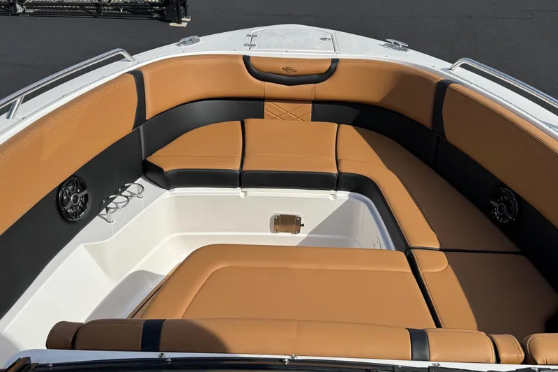 Slide: The Image of 2024 Chaparral 280 OSX boat interior with tan and black seating, featuring built-in speakers. - 2