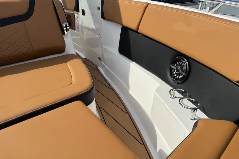 Slide: The Image of 2024 Chaparral 280 OSX interior with tan seating, cup holders, and speaker. - 6