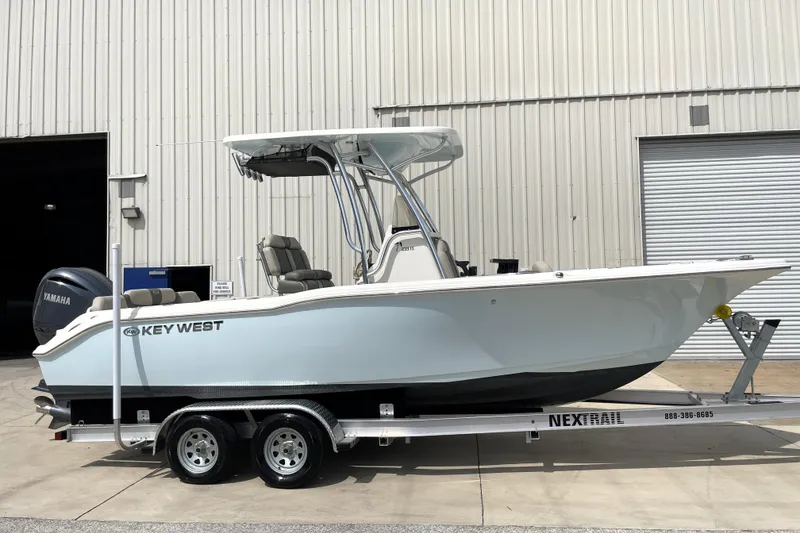 The Image of 2024 Key West 239 FS boat on trailer, parked outside a warehouse. - 1