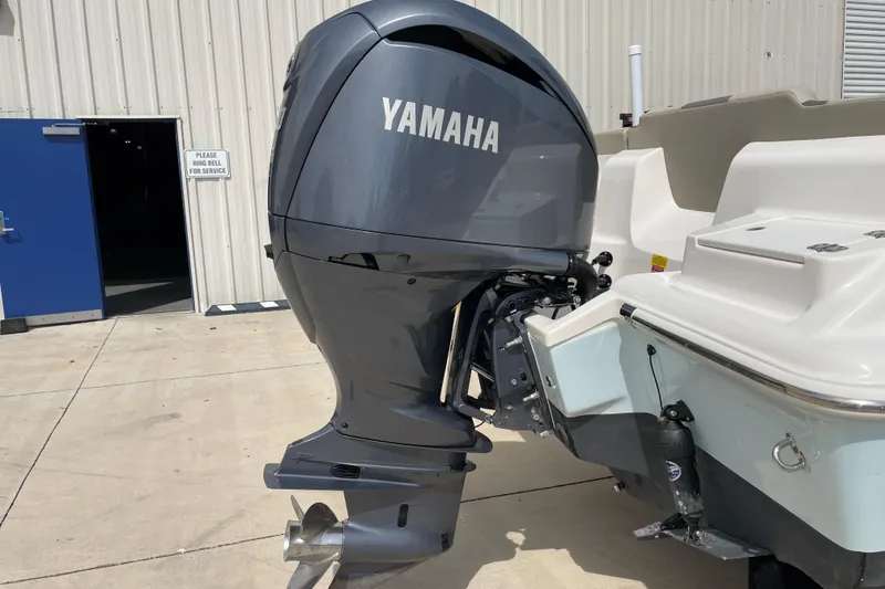 Slide: The Image of 2024 Key West 239 FS boat with Yamaha outboard motor, parked outside a building. - 11