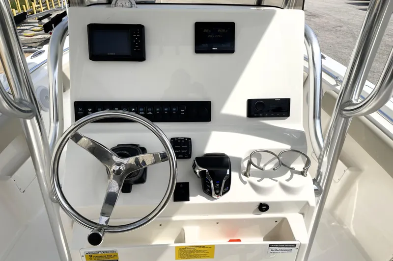 Slide: The Image of 2024 Key West 239 FS boat console with steering wheel and electronic controls. - 25