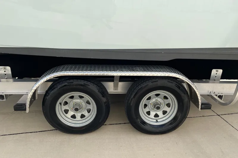 Slide: The Image of Trailer wheels of a 2024 Key West 239 FS boat on pavement. - 38