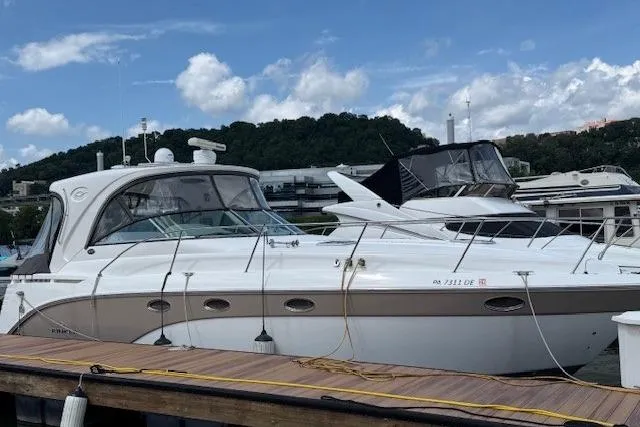 The Image of 2010 Rinker 400 Express Cruiser docked at marina under blue sky. - 0