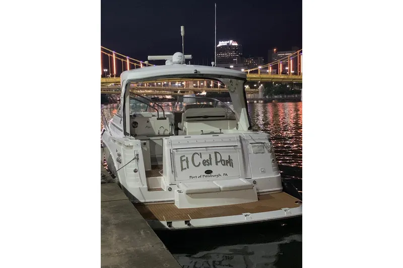 Slide: The Image of 2010 Rinker 400 Express Cruiser docked at night, Pittsburgh skyline in background. - 10