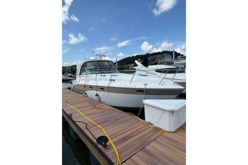 Slide: The Image of 2010 Rinker 400 Express Cruiser docked at marina under blue sky. - 12