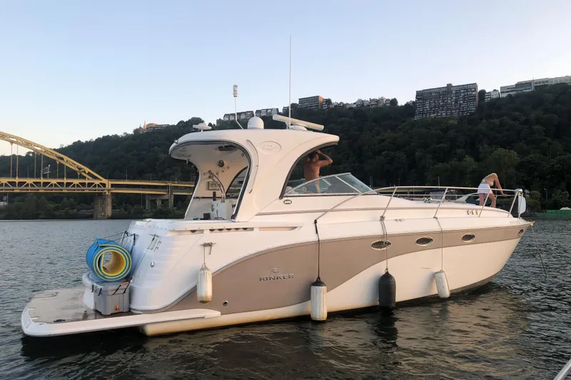 Slide: The Image of 2010 Rinker 400 Express Cruiser on a scenic river with a bridge backdrop. - 13