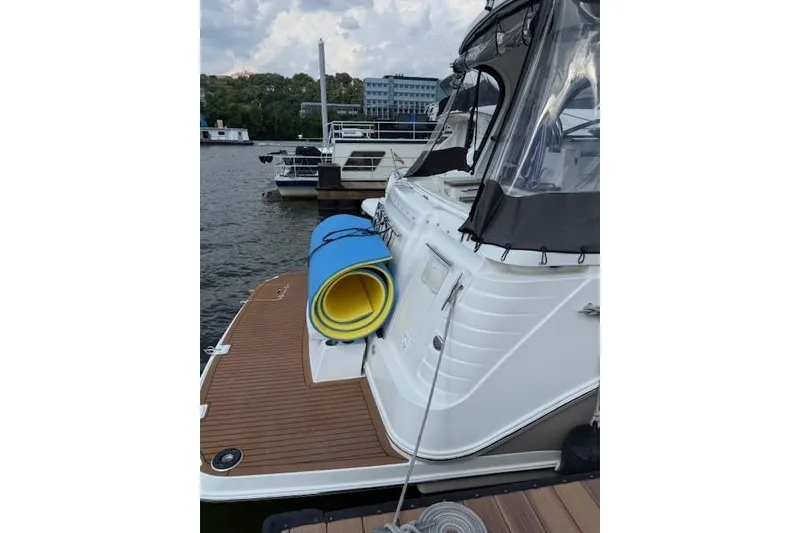 Slide: The Image of 2010 Rinker 400 Express Cruiser docked with rolled mats on deck. - 15