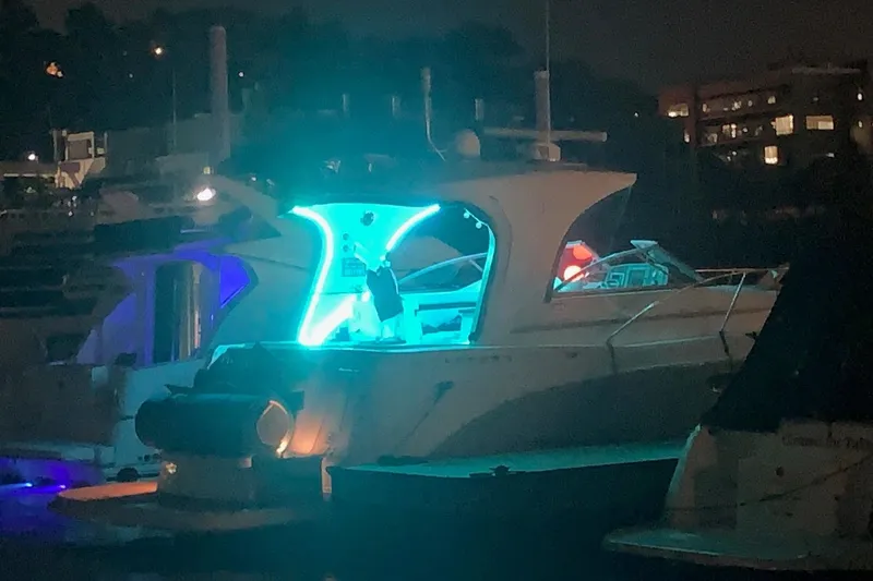 Slide: The Image of 2010 Rinker 400 Express Cruiser illuminated at night in a marina setting. - 17
