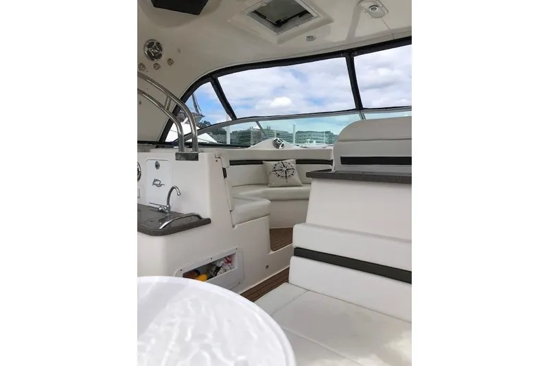 Slide: The Image of Interior of 2010 Rinker 400 Express Cruiser with white seating and modern design. - 18
