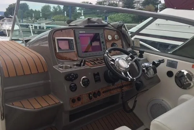 Slide: The Image of 2010 Rinker 400 Express Cruiser helm with navigation controls and wood accents. - 20