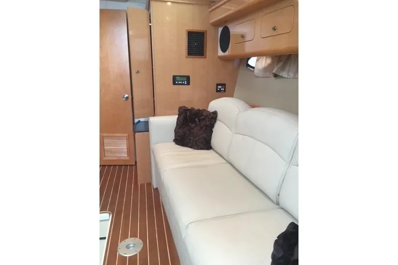 Slide: The Image of Interior of 2010 Rinker 400 Express Cruiser with white leather seating and wooden cabinetry. - 22
