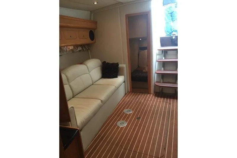 Slide: The Image of Interior of 2010 Rinker 400 Express Cruiser with sofa and wooden flooring. - 24