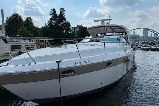 Slide: The Image of 2010 Rinker 400 Express Cruiser docked in a marina, under a partly cloudy sky. - 3