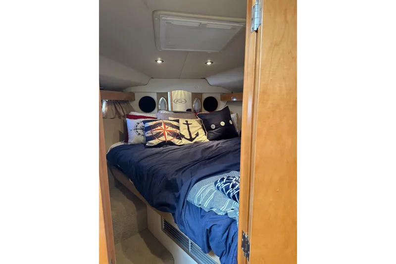 Slide: The Image of Cozy cabin interior of 2010 Rinker 400 Express Cruiser with nautical-themed bedding. - 31