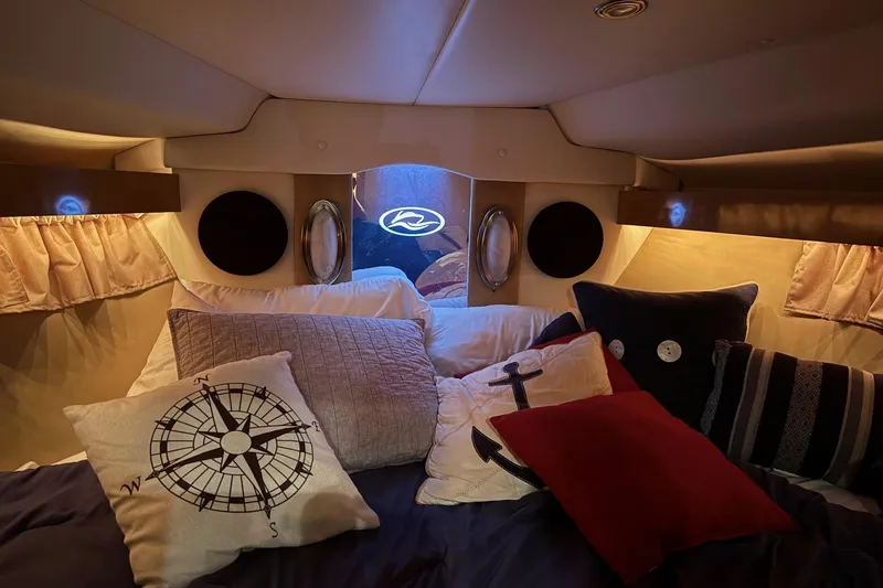 Slide: The Image of Cozy cabin interior of 2010 Rinker 400 Express Cruiser with nautical-themed pillows. - 32