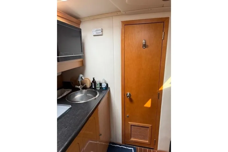 Slide: The Image of Interior of 2010 Rinker 400 Express Cruiser with sink and wooden door. - 36