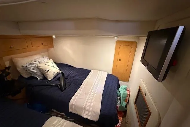 Slide: The Image of 2010 Rinker 400 Express Cruiser cabin with twin beds and wall-mounted TV. - 37