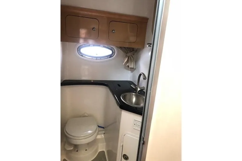 Slide: The Image of 2010 Rinker 400 Express Cruiser bathroom with sink, toilet, and storage cabinets. - 38