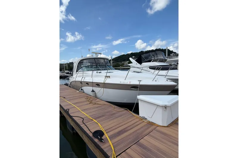 Slide: The Image of 2010 Rinker 400 Express Cruiser docked at marina under blue sky. - 4