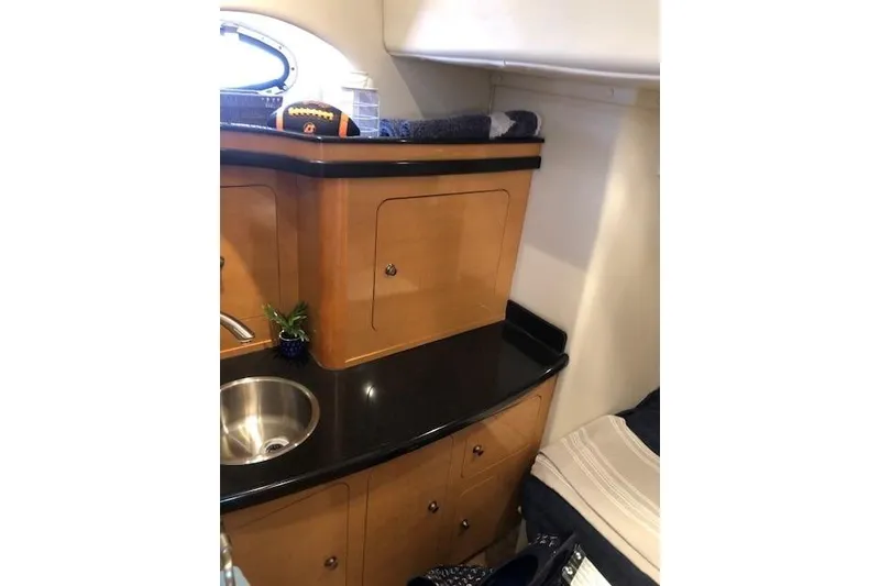 Slide: The Image of 2010 Rinker 400 Express Cruiser interior with wooden cabinetry and black countertop. - 41
