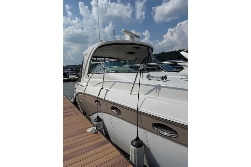 Slide: The Image of 2010 Rinker 400 Express Cruiser docked under a partly cloudy sky. - 6