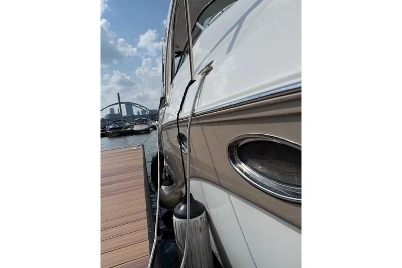 Slide: The Image of 2010 Rinker 400 Express Cruiser docked, showcasing sleek design and chrome details. - 7