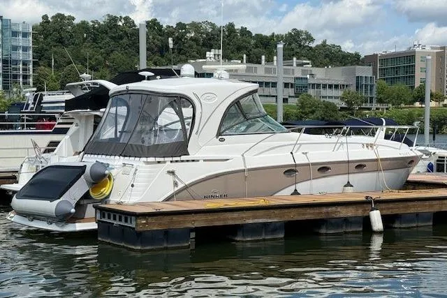Slide: The Image of 2010 Rinker 400 Express Cruiser docked at a marina, surrounded by modern buildings. - 9