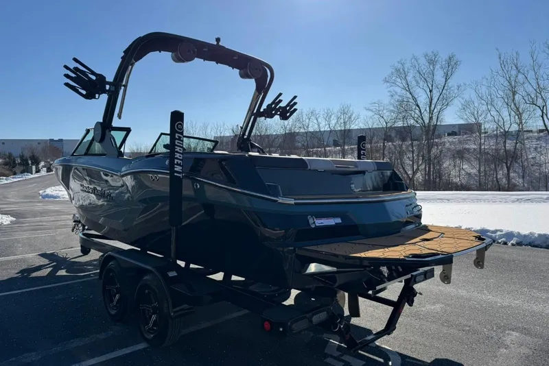 Slide: The Image of 2025 MasterCraft NXT23 boat on trailer in snowy parking lot. - 3