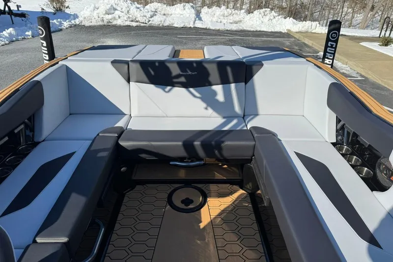 Slide: The Image of 2025 MasterCraft NXT23 boat interior with gray seating and hexagonal floor design. - 5