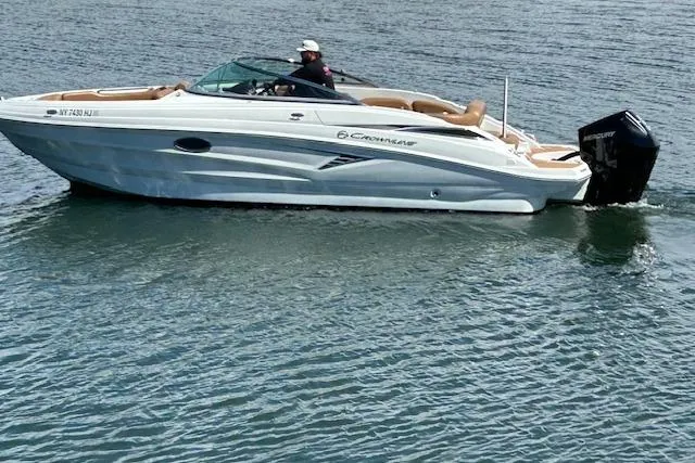 The Image of 2023 Crownline 250 XSS boat cruising on calm water with a person onboard. - 0