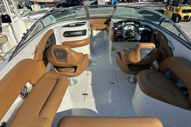 Slide: The Image of 2023 Crownline 250 XSS boat interior with tan seating and modern dashboard. - 15