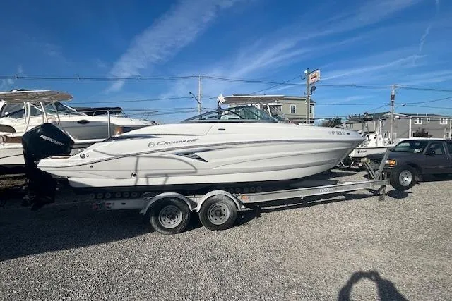 Slide: The Image of 2023 Crownline 250 XSS boat on trailer under clear blue sky. - 4