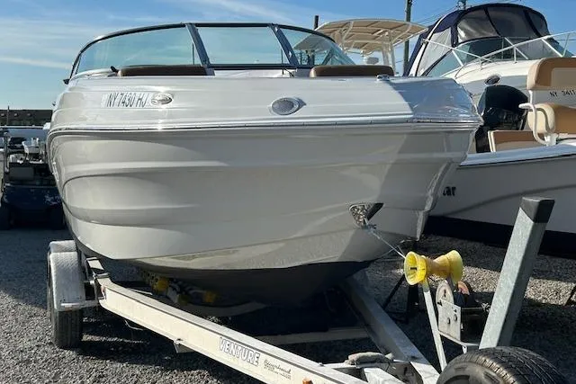 Slide: The Image of 2023 Crownline 250 XSS boat on trailer, parked in marina. - 5