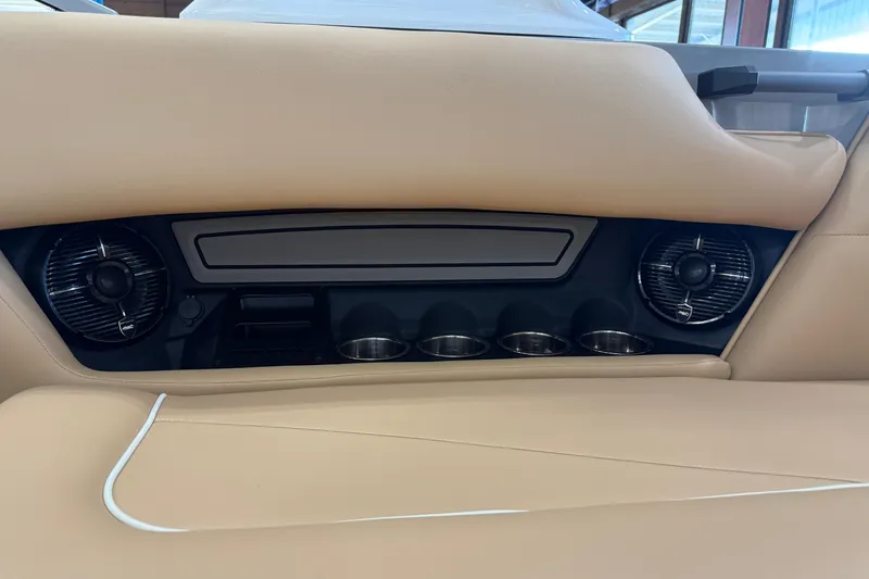 Slide: The Image of 2026 Moomba Craz interior with cup holders and speakers, featuring beige upholstery. - 19