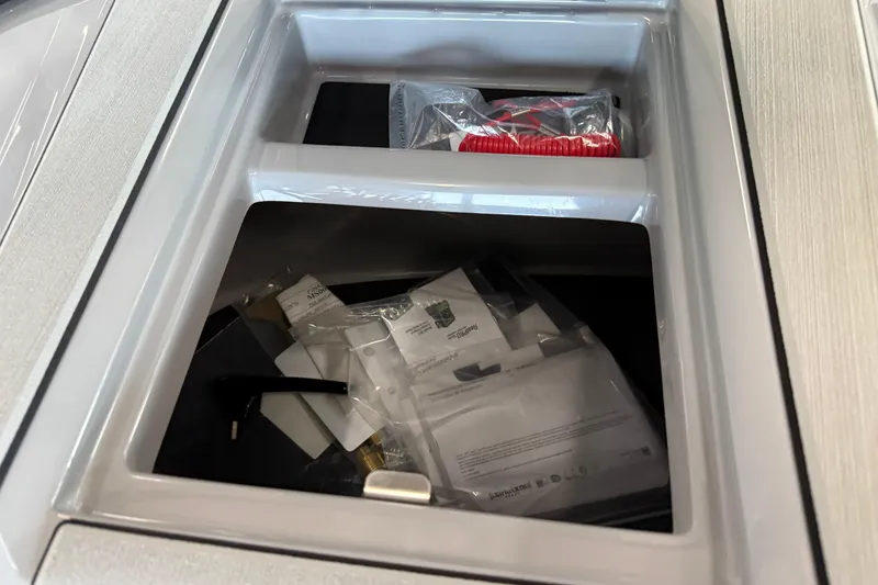 Slide: The Image of Storage compartment in 2026 Moomba Craz boat, containing various items and documents. - 33