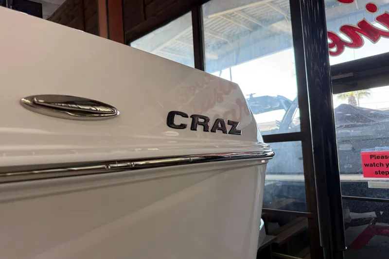 Slide: The Image of 2026 Moomba Craz boat in showroom, close-up of model name on hull. - 5